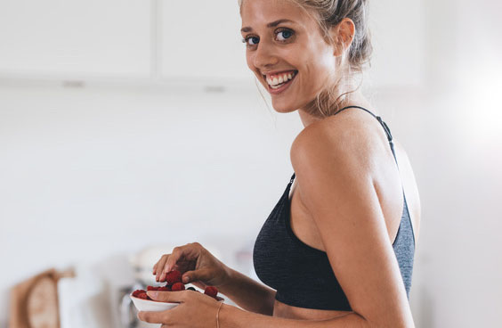 Femme souriante qui mange des fruits
